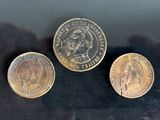 three different types of coins sitting on a black surface