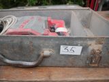 a metal box with tools inside of it on a table