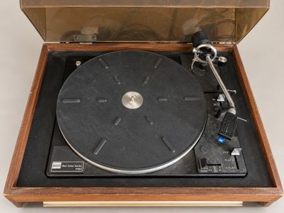 a record player sitting in a wooden box on a white surface