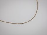 un collier en chaîne en or avec un fermoir en diamant sur fond blanc
