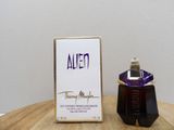 an image of a bottle of perfume sitting on top of a wooden table