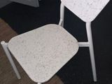 two white chairs sitting next to each other in a room