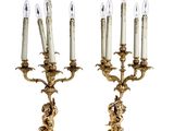 une paire de chandeliers anciens en laiton, chacun orné d'une bougie