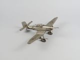 une maquette argentée d'un petit avion posée sur une surface blanche