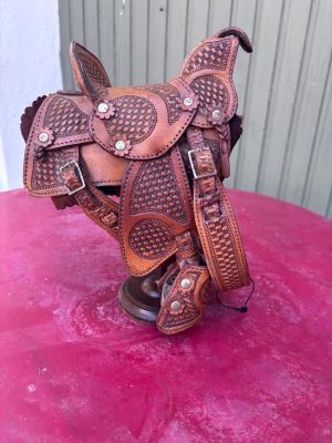 un gros plan d'une selle de cheval posée sur une surface rose