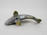 figurine of a fish on a white surface with a tag on it