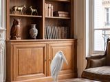 a white bird sitting on a coffee table in front of a bookshelf