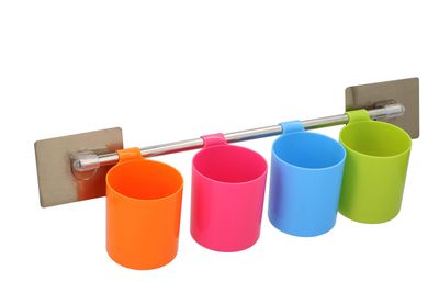 Des tasses aux couleurs vives sont alignées sur un support