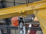 a yellow crane hanging from the ceiling of a building