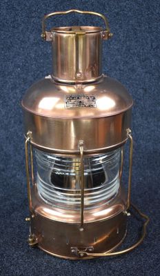une lanterne ancienne en cuivre avec un dôme en verre sur fond bleu