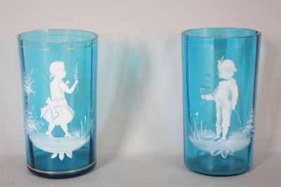deux vases en verre bleu ornés de silhouettes blanches