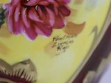 a close up of a vase with flowers painted on it