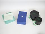 three black boxes with green ribbons and a blue box with a white ribbon