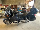une moto noire garée dans un garage avec d'autres motos