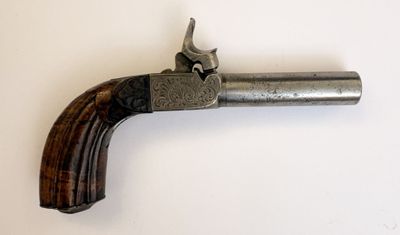 un vieux pistolet avec une crosse en bois accroché à un mur blanc