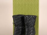 une paire de bottes noires posée sur une boîte verte