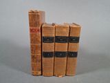 quatre vieux livres empilés les uns sur les autres sur une table