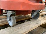 a red wheel on a wooden pallet in a warehouse