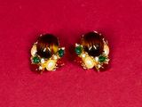 two pairs of earrings on a red surface with a red background