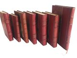 six livres rouges alignés sur une surface blanche