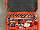 un ensemble d'outils rangés dans une boîte à outils posée par terre