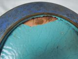 a close up of a blue vase with a hole in it