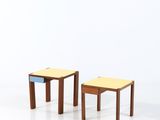 deux petits tabourets en bois placés l'un à côté de l'autre sur une surface blanche