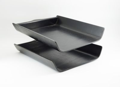 two black plastic trays stacked on top of each other on a white surface