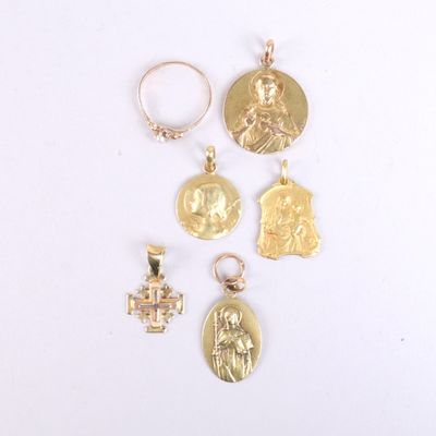 four gold - plated religious pendants on a white surface