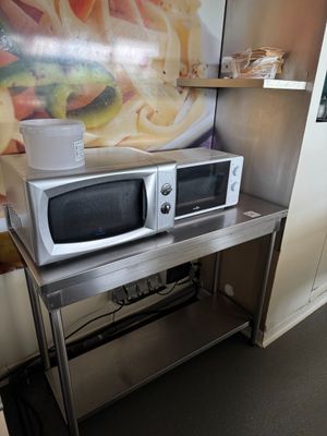 deux fours à micro-ondes posés sur une table en métal dans une cuisine