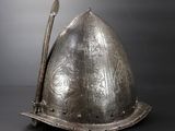 a silver helmet with a metal handle on a table