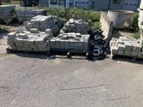 a pile of bricks sitting on the ground next to a trash can