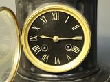 a black clock with roman numerals on it