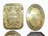 four different types of brass plaques are displayed on a white surface