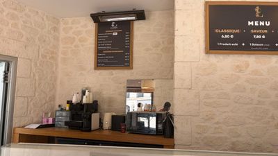 a picture of a coffee shop with a menu on the wall