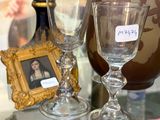 deux verres à vin et un vase posés sur une table en verre