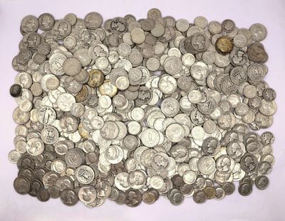 a pile of silver coins sitting on a white surface