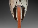 pair of wooden and metal helmets on stands on a gray background