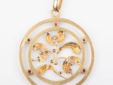 a close up of a gold plated pendant with a flower design