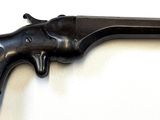 an old black revolver on a white surface with a white background