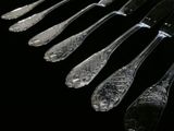 five silver spoons and six silver spoons on a black background
