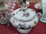 une table recouverte d'une nappe rouge, sur laquelle sont disposés des vases et des assiettes