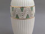 un vase blanc orné d'un motif vert et blanc