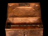 an old metal box with a handle on a black background