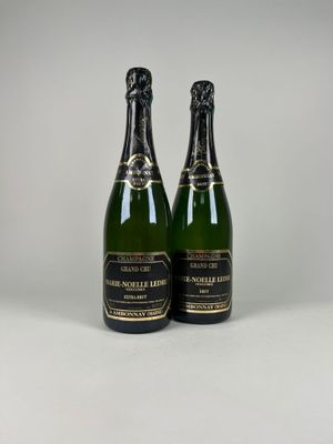 deux bouteilles de champagne posées l'une à côté de l'autre sur une table