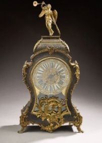 a clock with a statue on top of it on a table