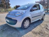 a small silver car parked in a gravel lot
