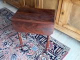 une petite table en bois posée sur un tapis dans une pièce