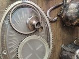 many silver teapots and cups on a wooden table