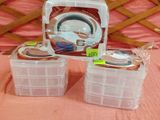 trois récipients en plastique posés sur un lit recouvert d'une couverture rose